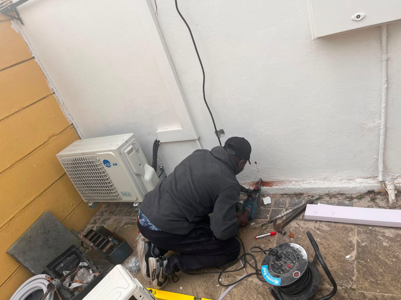 Mike Cooling Solutions technician installing an outdoor condenser unit at a home