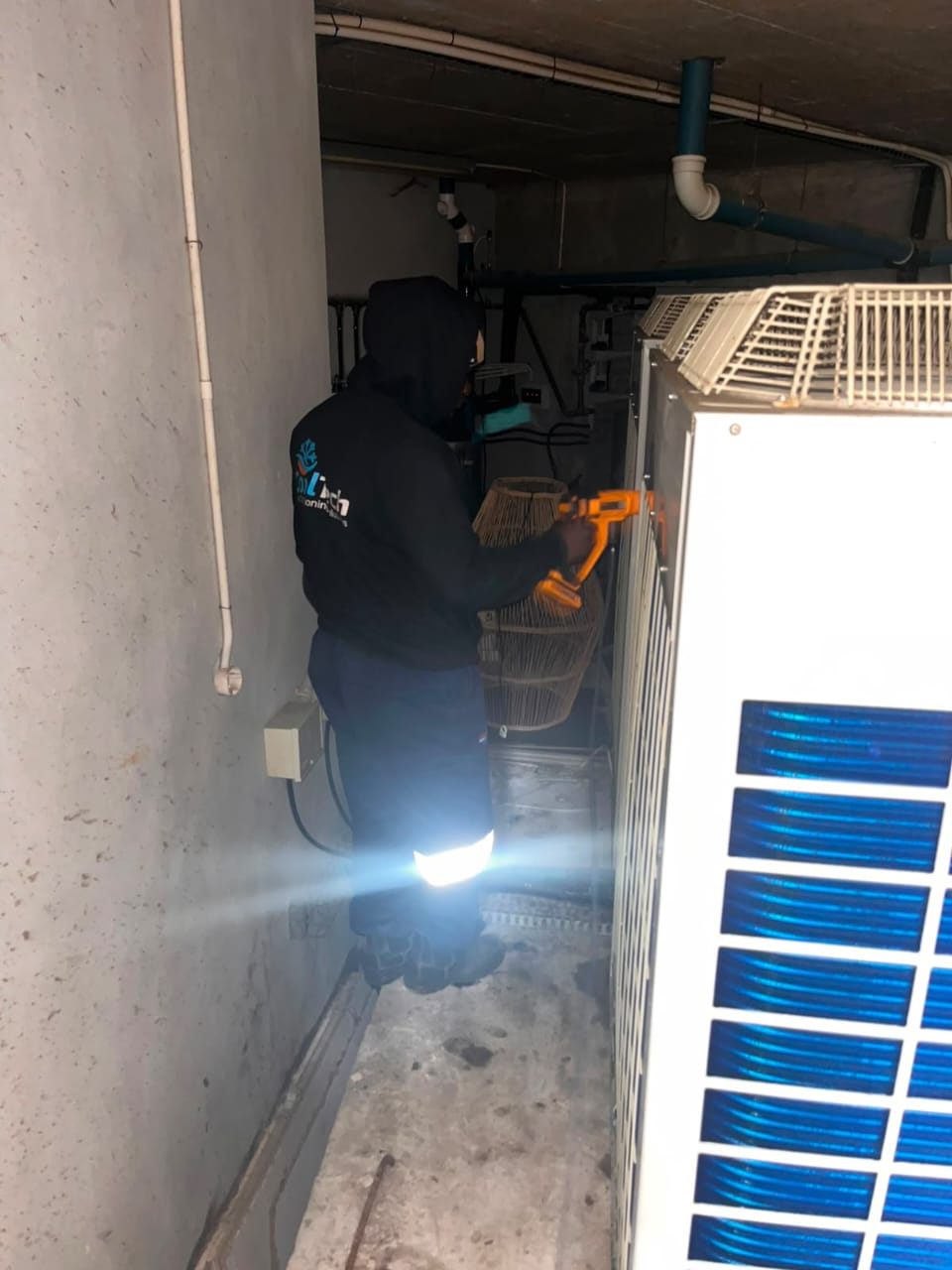 Technician servicing a plant-room cooling unit after hours