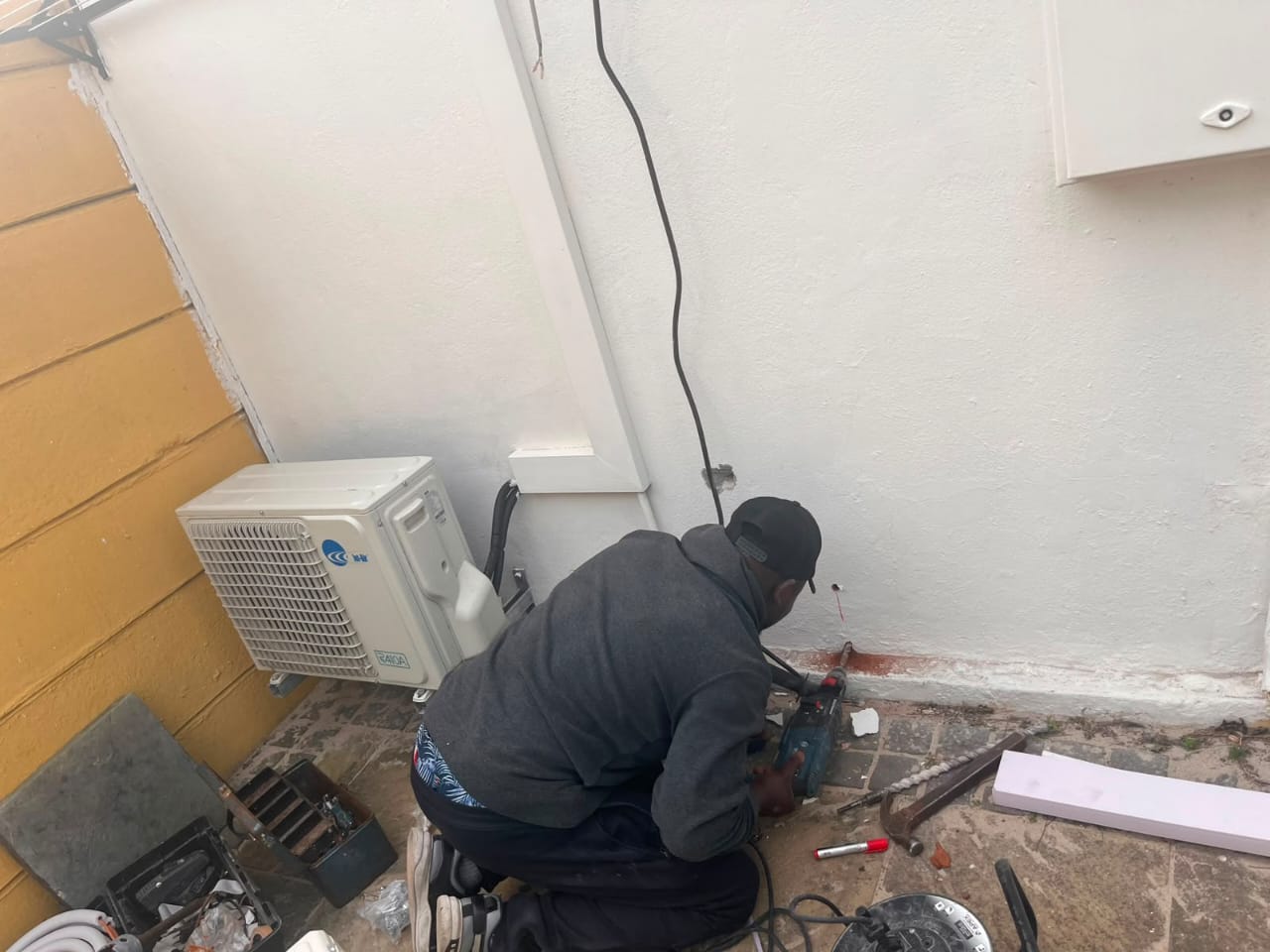 Outdoor condenser unit installation with neat pipework and drainage